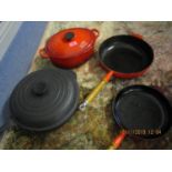Le Creuset - two red frying pans and one casserole dish, together with a black Le Creuset frying pan