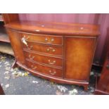 A reproduction mahogany bow fronted sideboard having four drawers, flanked by two cupboard doors,