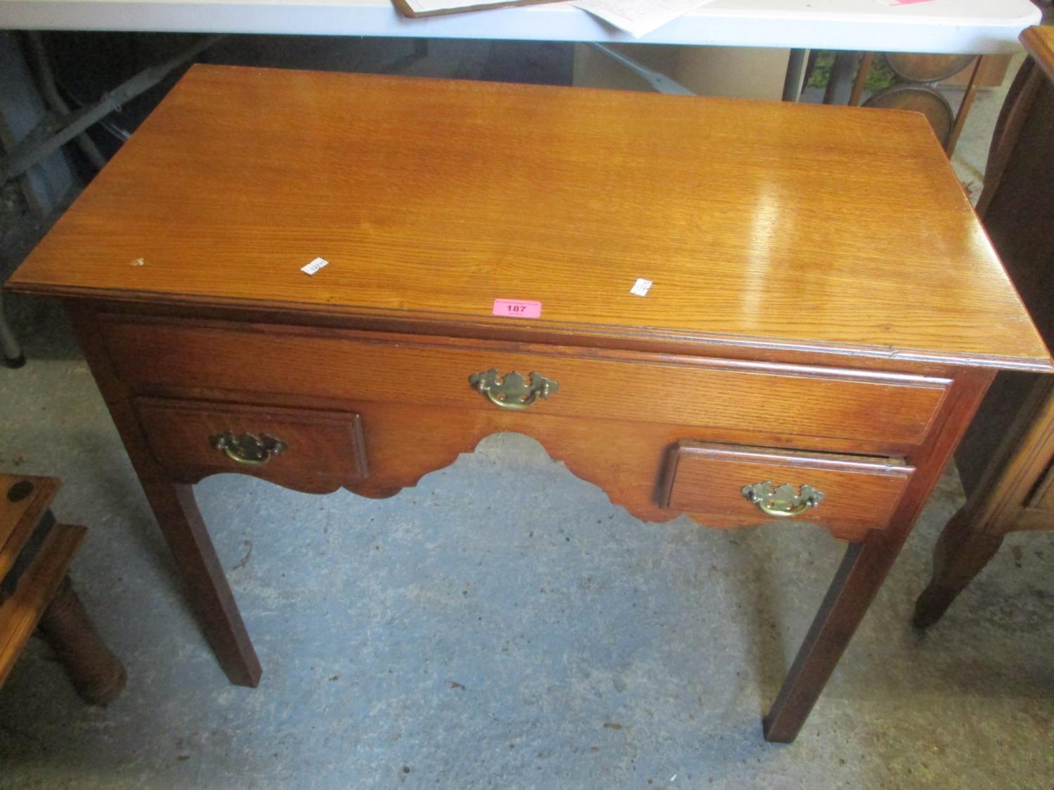 A reproduction Georgian style oak desk having one long and two short drawers, 27 1/2" h x 34"w