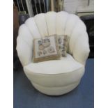 An Art Deco inspired cream fabric upholstered armchair