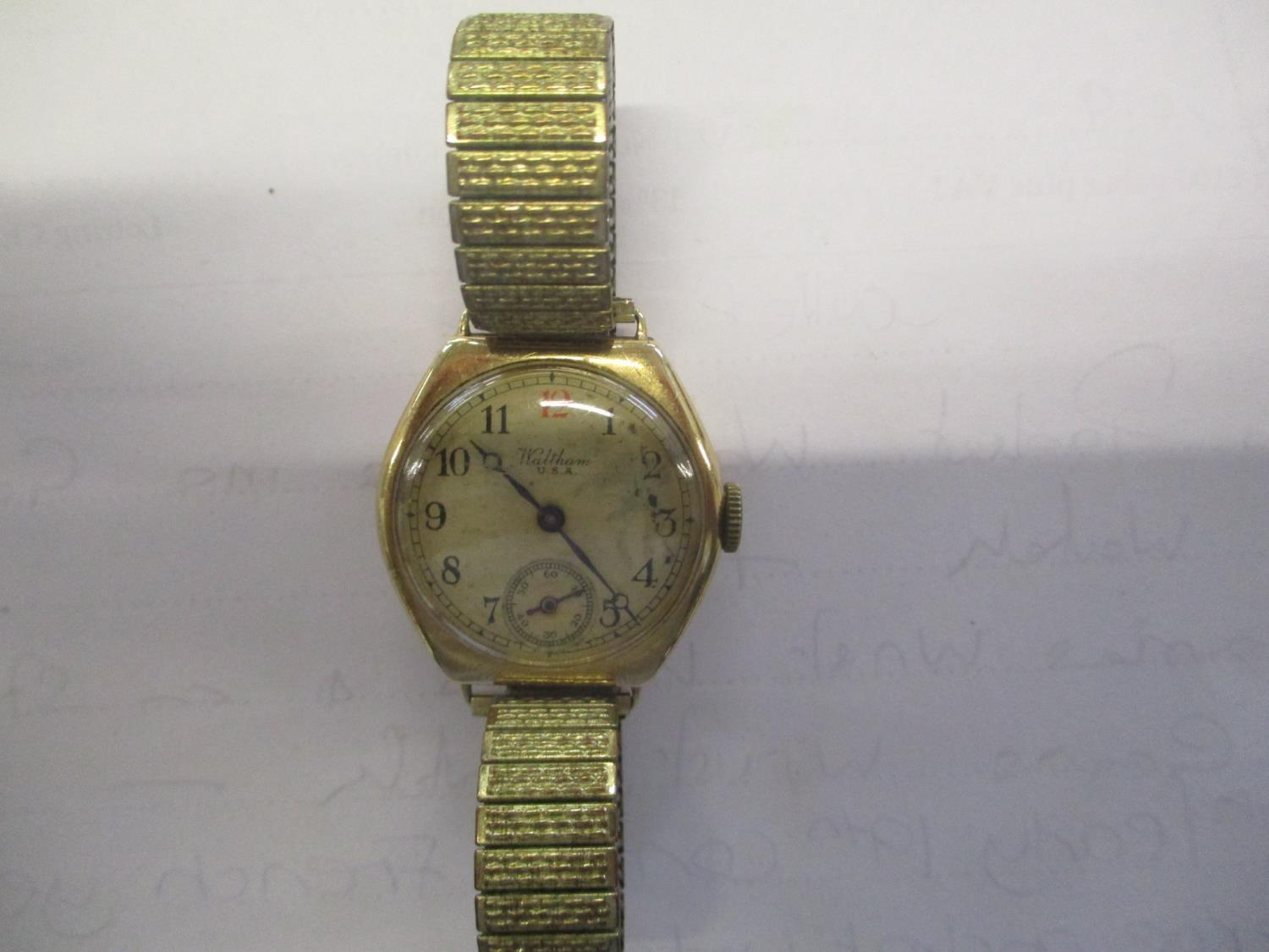 A 1930s Waltham 9ct gold cushion cased wrist watch having a cream dial with Arabic numerals, red