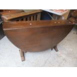 A mid 20th century Ercol style dark elm fall flap table, 28" h x 50" and four treen radiator covers