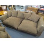 A modern brown three-seater sofa with overstuffed cushions
