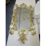 A modern gilt framed mirror decorated with scrolls and flowers