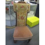 A Victorian walnut framed prayer chair having a tapestry upholstered back, fluted columns and