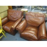 A pair of modern brown leather upholstered armchairs