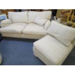 A three-person settee upholstered in an oatmeal fabric, raised on turned, tapered beech legs and
