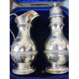 A silver cream jug and sugar caster, boxed