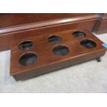 A 19th century mahogany six wine bottle holder on castors