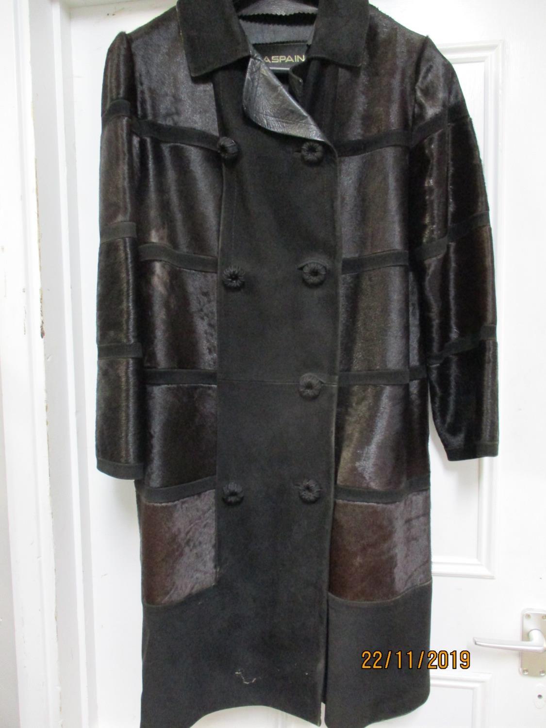 A bull skin short hair and leather ladies, knee length coat, circa 1960, with fabric buttons,