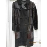 A bull skin short hair and leather ladies, knee length coat, circa 1960, with fabric buttons,