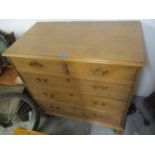 An early 19th century oak chest of five drawers on bracket feet