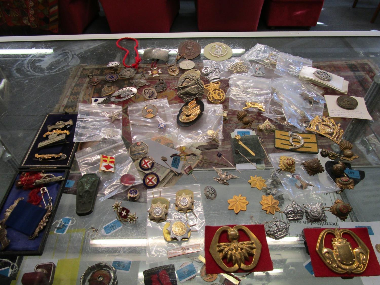 A quantity of military cap badges, school and club badges, sports badges and medals and other