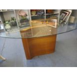 A modern oval glass topped contemporary dining table on walnut veneered base, 29 1/4" x 71"