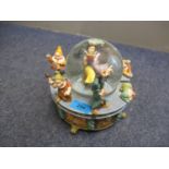 A Disney Snow White and the Seven Dwarfs snow globe, playing Whistle a Happy Tune