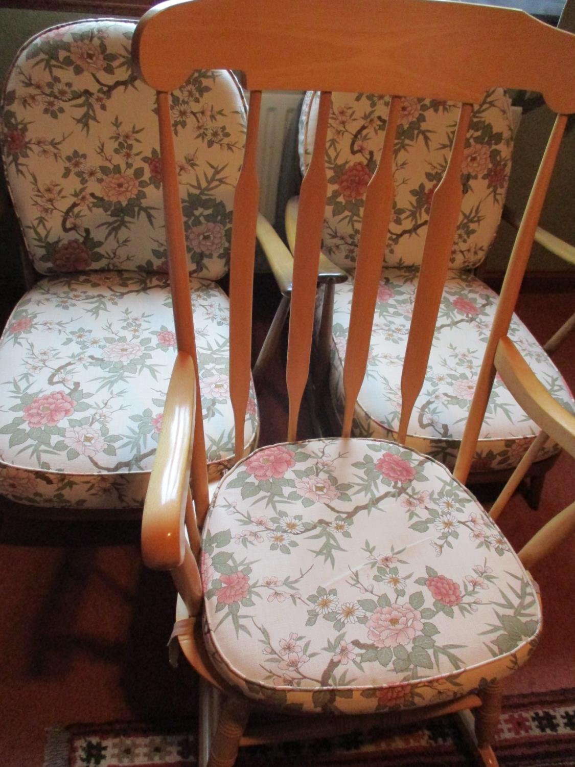 A pair of Ercol easy chairs with floral loose cushions and a beech rocking chair