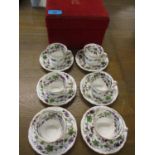 A set of six Royal Crown Derby coffee cans and saucers having a white background with grapevine