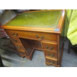 A reproduction yew low boy with inset green scriber, one long drawer flanked by six short with