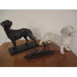 Two models of dogs and a bronze model of a canoe with two figures rowing