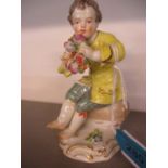 A late 19th century Meissen figure of a boy wearing a yellow jacket, sat on a hod of flowers,