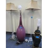 A pair of contemporary glass table lamps in column form, together with a purple glass table lamp and