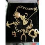 A 9ct gold charm bracelet with lock catch and three charms, along with a loose 9ct gold hear