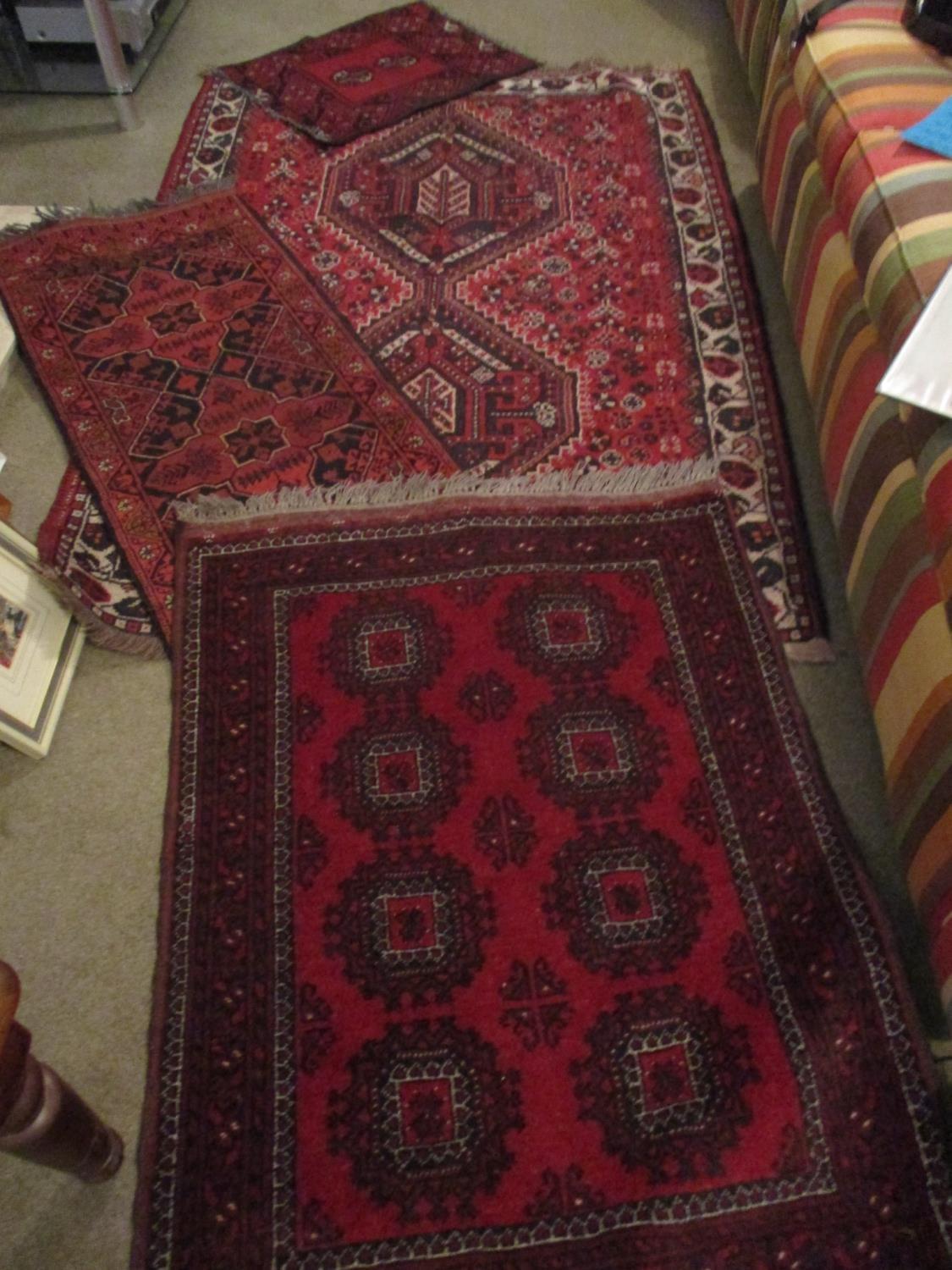 A Turkish red ground gull decorated rug with a small Bokhara prayer mat with red ground and barbers?