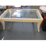 A contemporary white painted and glass topped coffee table