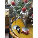 A pair of modern metal candlestands fashioned as plants with red candles and a pair of Venetian