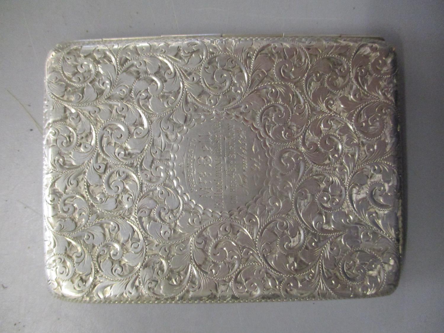 A Victorian silver card case having all over scroll decoration with inscription