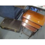 An early 20th century mahogany nest of three tables, together with a suitcase