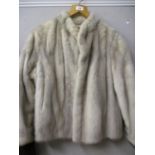 An Arctic mink box jacket with hemmed cuffs, 23" long, x 36" chest approximately