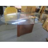 A modern oval glass topped contemporary dining table on walnut veneered base, 29 1/4"h x 71"w
