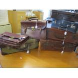 A selection of vintage leather and canvas suitcases and two leather briefcases