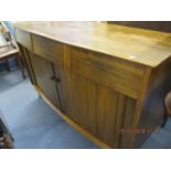 A mid 20th century walnut sideboard with three drawers and two tambour doors