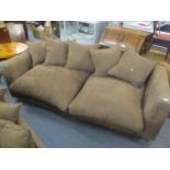 A modern brown three-seater sofa with overstuffed cushions Location C