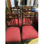 A set of four Victorian walnut framed dining chairs with spindle backs and upholstered seats, on