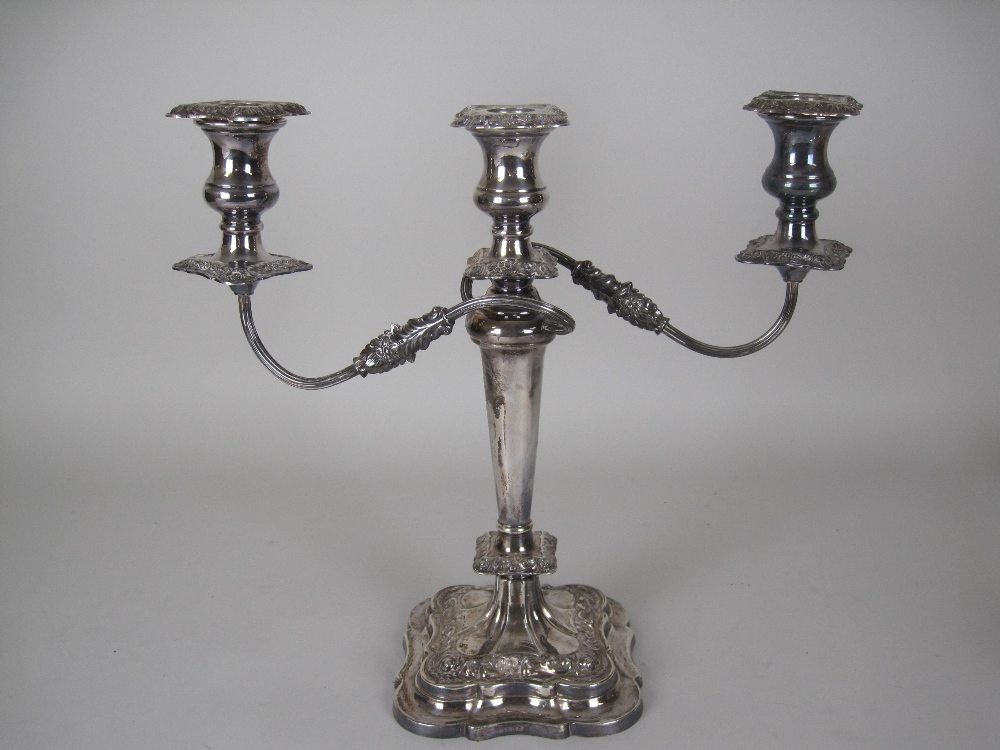 An Elizabeth II silver two branch three light Candle Holder with tapering column on shaped