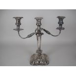 An Elizabeth II silver two branch three light Candle Holder with tapering column on shaped