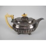 A George III silver Teapot of boat shape, semi-fluted on ball feet engraved Welsh crest and motto,