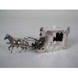 A Continental silver horse drawn Carriage with figures and cherub on sledge