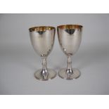 A pair of Victorian silver Goblets with single knop stems, beaded circular bases, gilt interiors,