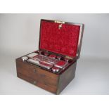 An early Victorian rosewood Dressing Case with engraved silver lidded blue flashed glass jars and