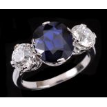 A Sapphire and Diamond three stone Ring claw-set cushion-cut sapphire, 3.37cts, between two old-