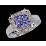 A Tanzanite and Diamond Cluster Ring peg-set nine round tanzanites within square frame of illusion-