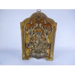 A gilt metal small wall mounted Font with Christ and the lamb surrounded by cherubs and scrolls,