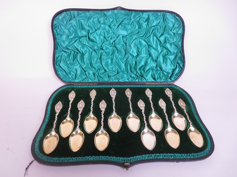 One dozen Victorian silver-gilt Dessert Spoons with scroll stems and figure finials, London 1893, in - Image 2 of 2