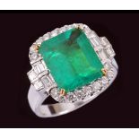 An Emerald and Diamond Cluster Ring corner claw-set step-cut emerald, 4.18cts, within frame of