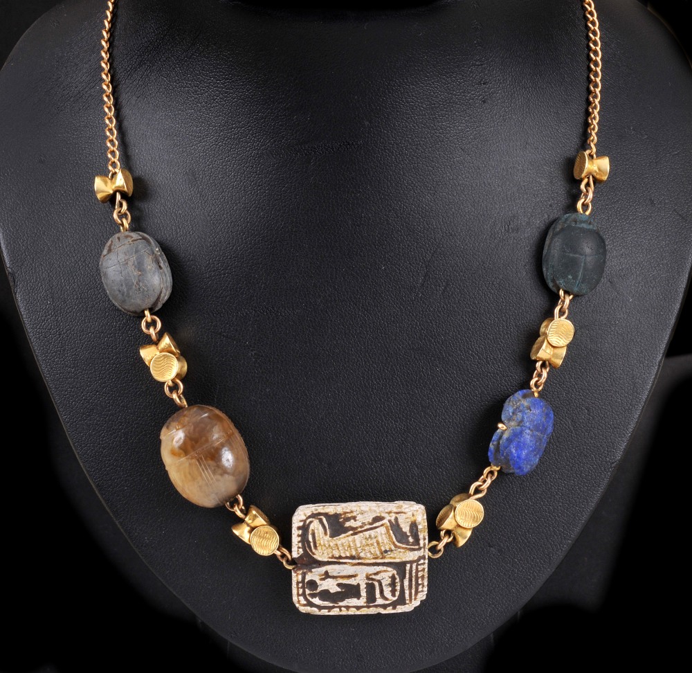 An Egyptian Necklace having central engraved tablet between four various seals formed as scarab