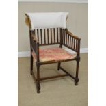 An Arts and Crafts mahogany Elbow Chair with slatted back, shaped arms on turned front suports